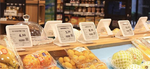 Electronic shelf labels on stands above fresh fruit