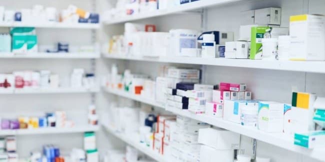 Pharmacy shelves stocked with medicine boxes
